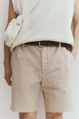 Short color beige de sarga de algodón suave, con elástico en los laterales de la cintura, cierre con botón, bolsillos al bies y bolsillos de atrás ribeteados con botón.