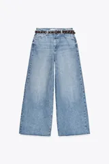 Pantalón de jean celeste de tiro alto, corte wide leg cropped, con cinco bolsillos y cinturón marrón con tachas.