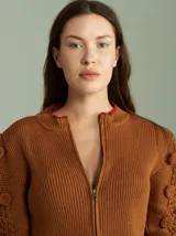 Cardigan marrón de tejido de punto con cierre frontal, cuello redondo y mangas abullonadas con apliques de pompones.