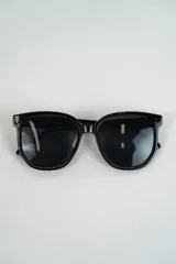 Lentes de sol negros con montura cuadrada de acetato.