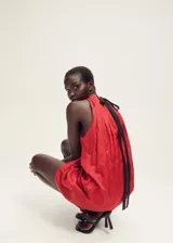 Vestido corto rojo con cuello halter fruncido y espalda descubierta.