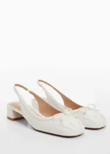 Zapato destalonado blanco con tacón bloque, punta redonda y lazo decorativo.