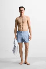 Bañador corto celeste de tejido técnico con cintura elástica ajustable con cordón interior y trabillas laterales. Cuenta con bolsillos frontales, bolsillo trasero con cierre de cremallera y forro interior.