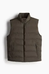 Chaleco puffer color marrón con cuello elevado y cierre frontal. Cuenta con bolsillos laterales con cierre y un bolsillo interior con botón a presión.