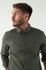 Camisa de hombre color marrón con efecto stone wash, fit regular, cuello americano, cierre con botones, dos bolsillos frontales con botón y mangas largas con puños abotonados.