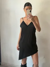 Vestido corto negro con breteles finos y escote en V con detalle de encaje.