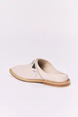 Sueco de cuero negro con detalle de apliques metálicos triangulares plateados.