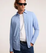 Camisa de vestir celeste en modelo slim fit, con cuello inglés, abotonada adelante, de manga larga con botones en los puños. Confeccionada con tecnología easy care performance que permite mayor elasticidad, secado rápido y menos arrugas.