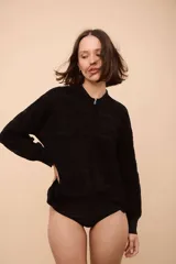 Campera con cierre frontal, de tejido con ondas y rayas horizontales verdes, rojas y negras.