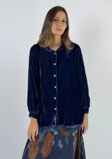 Camisa de terciopelo color azul con manga larga y cierre frontal de botones.