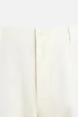 Pantalón chino color crema de corte recto, confeccionado en tejido de algodón con elasticidad. Cuenta con bolsillos frontales y traseros de plastrón con botón. Cierre frontal con cremallera y botón.