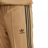 Pantalón deportivo Adidas Adicolor Classics color marrón claro con tres rayas negras a los costados y logo bordado en negro.