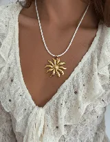 Collar dorado con dije de acero quirúrgico hipoalergénico en forma de girasol y cadena de cordón trenzado color dorado.