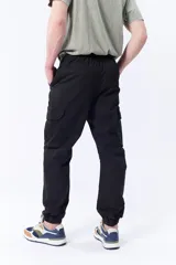 Pantalón cargo jogger color negro con cintura elastizada ajustable con cordón y puños elastizados.