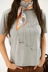 Remera blanca con estampado de moldes de costura en color marrón.