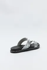 Sandalias negras con tiras anchas y microtachas metálicas.