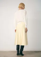 Cardigan de punto fino color crema, con cuello en V, cierre frontal con botones y mangas largas.