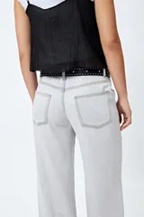 Pantalón de jean gris oscuro, tiro bajo, corte baggy y doble bolsillo.