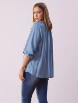 Blusa celeste de tencel, marca Marissa Olivia, con cuello a la base, escote en V con aplique de cordel y lazo de ajuste. Manga larga amplia con puño elastizado.