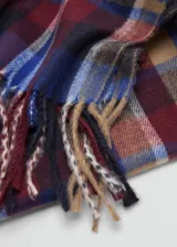 Bufanda rectangular con diseño de cuadros tartán en tonos azul, rojo, marrón y beige, con flecos en los extremos.