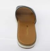 Sandalia con capellada de cuero negro con textura de piel de serpiente. Suela blanca con base marrón.