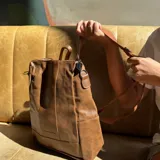Mochila marrón de eco-cuero con cierre superior y correas ajustables.