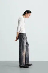 Pantalón de jean azul con lavado gastado, corte holgado y cinco bolsillos.