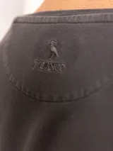 Remera de manga larga gris oscuro con cuello redondo y bolsillo en el pecho.