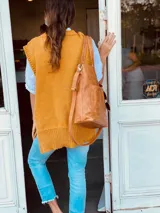Bolso tipo tote bag color suela, de cuero, con doble asa de mano y correa larga extraíble y ajustable. Tiene dos bolsillos externos grandes.