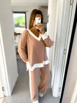 Conjunto de buzo y pantalón de morley beige con detalles en crudo. El buzo es de corte amplio con cuello en V y puños blancos. El pantalón es de corte recto con una franja blanca lateral.