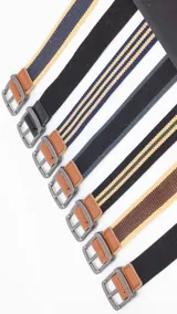 Cinturón casual negro de tela canvas con hebilla metálica plateada y detalles en cuero sintético negro.