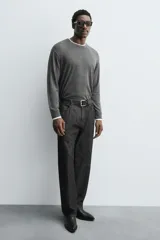 Bota corta negra estilo cowboy, con caña lisa, punta cuadrada y tirador trasero. Ajuste mediante cremallera lateral y tacón bajo.