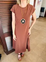Vestido midi negro de algodón, con mangas cortas, cuello redondo y bolsillos laterales.
