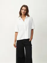 Camisa blanca de mangas cortas con textura.