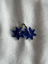 Par de aros dorados con forma de estrella negra.