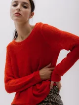 Sweater de punto color rojo ladrillo, de corte holgado y mangas largas.