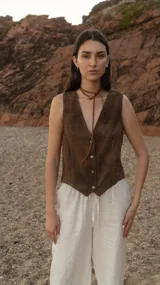 Chaleco marrón de cuero vacuno italiano con acabado gastado, cuello en V y cierre frontal con botones.