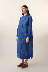 Vestido largo azul con estampado floral, cuello mao y mangas largas.