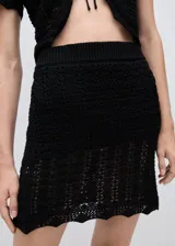 Minifalda negra de tejido de punto calado, con cintura elástica y corte ajustado.