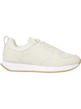 Zapatillas deportivas Tommy Hilfiger color crema, de estilo running, con cordones y suela de goma color caramelo. Presentan el logo de la marca en el lateral y detalles distintivos de Tommy Hilfiger.
