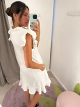 Vestido midi blanco con escote en V, abotonado al frente, mangas cortas con volados y falda evasé.