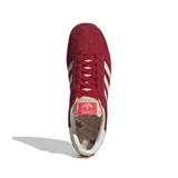 Championes Adidas Gazelle color bordó con las tres tiras laterales blancas y suela color crema.