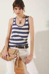 Musculosa a rayas horizontales azules y blancas, con cuello redondo y sisas con ribete azul.