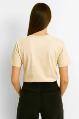 Remera color crema de algodón con cuello redondo y mangas cortas. Estampado frontal con dibujo de langosta y ostras sobre fondo de rayas verticales color naranja.