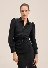 Vestido camisero midi negro con textura de mini rombos, corte entallado, cuello camisero, cierre frontal con botones, mangas largas abullonadas y frunces en la cintura.