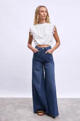 Remera blanca de algodón con mangas cortas y detalle de encaje calado en los hombros.