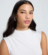 Blusa sin mangas color celeste, con cuello alto y drapeados laterales.