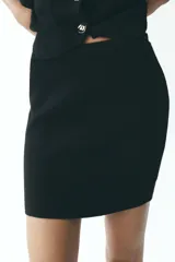Minifalda negra de punto con cintura elástica.