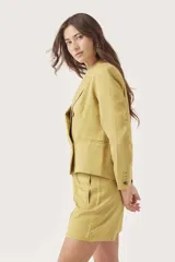 Blazer cruzado color amarillo ocre, con solapas de muesca y doble botonadura.