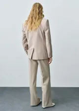 Pantalón de vestir color beige de corte palazzo, tiro medio y tejido ligero.